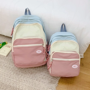 Detail of macaron patchwork backpack set showing pastel colors and branded logo label