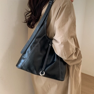 Model shows the large black tote bag featuring distinctive white contrast stitching detail