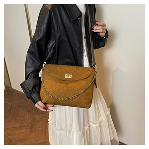 Nahaufnahme der braunen Wildledertasche mit Steppmuster und goldener Kette
