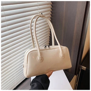 Close-up of cream leather Boston bag with SHIYUBAG embossed logo and smooth dual handles