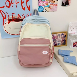 Detail of macaron colorblock backpack featuring multi-pocket design and woven zipper pulls