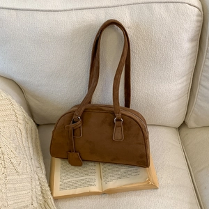 Detail of dark brown frosted leather Boston bag texture on a vintage book background