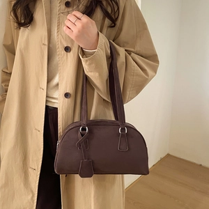 Close-up of matte dark brown Boston bag with silver rings and pleated opening detail