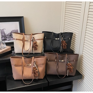 Detailed display of four matte leather tote bags with cute bear charms on a display stand