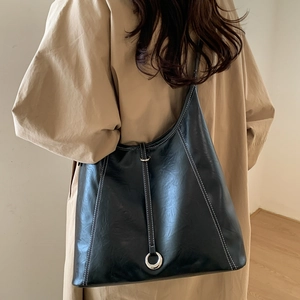 Detail shot of large black tote bag with white contrast stitching and silver ring buckle