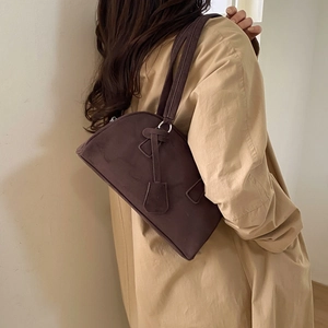 Detail of vintage coffee brown frosted leather Boston bag carried by a fashion model