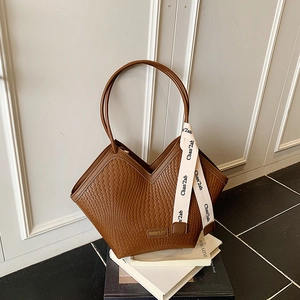 Detailed macro view of brown woven texture leather tote bag with Fashion & Bag metal tag