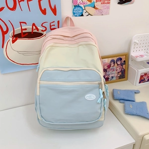 Detail of macaron-colored patchwork backpack with multi-pocket design on study desk