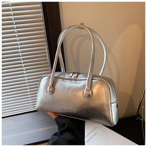 Detail of silver handbag featuring metallic crinkled texture and embossed brand logo