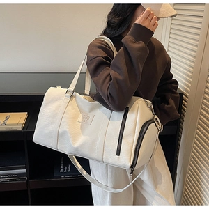 Détail du sac de sport en cuir PU blanc avec texture litchi et bandoulière réglable