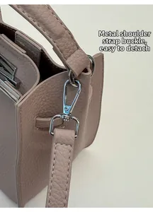 Detail of silver metal hook and detachable strap on pink lychee leather bucket bag
