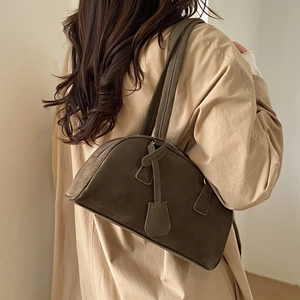 Brown frosted leather Boston bag detail shown on shoulder with long dual straps