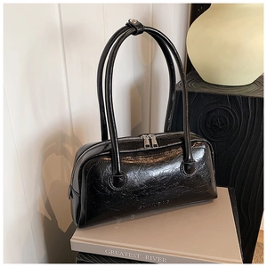 Detail of glossy black patent leather Boston bag with silver double zippers and handles