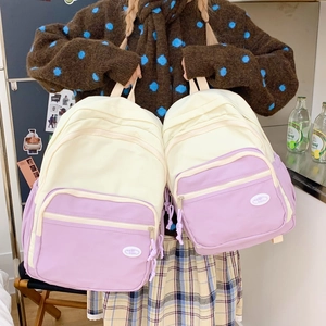 Detail of color-block macaron backpack with durable canvas texture and woven zip pulls