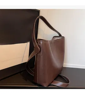 Detailed view of dark brown PU leather bucket bag with white contrast stitching detail