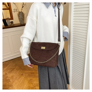 Detailaufnahme der dunkelbraunen Stepptasche mit goldenem Drehverschluss und Kettenriemen