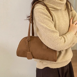 Detail of vintage brown suede Boston bag showing texture and styling on model