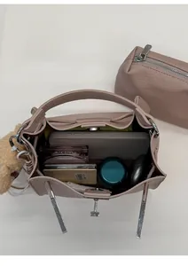 Interior view showing the large capacity of the pink leather bucket bag and pouch
