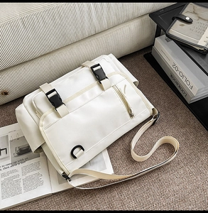 Detail of off-white waterproof messenger bag with durable plastic buckle and utility strap
