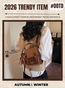 Brown vintage backpack with double buckle straps and cute teddy bear charm detail