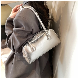 Detailed view of silver metallic shoulder bag with crackled leather texture and logo
