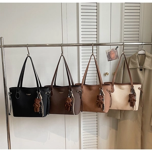 Minimalist tote bags in four colors with cute bear charms hanging on a metal rack