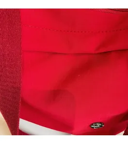 Vue détaillée de la texture du tissu en nylon rouge et coutures de la sacoche