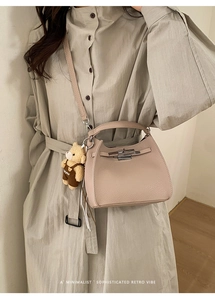 Detail of apricot lychee pattern bucket bag with metal lock and cute bear charm