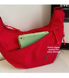 Poche zippée avant du sac croissant en nylon rouge montrant le rangement d'une tablette