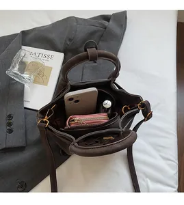 Vue intérieure d'un sac seau marron foncé montrant un grand espace pour accessoires