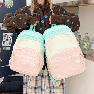 Detail of color-block macaron backpack with multiple compartments and nylon fabric