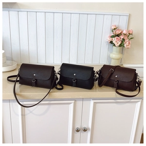 Detailed view of vintage flap crossbody bags in coffee, black, and reddish-brown leather