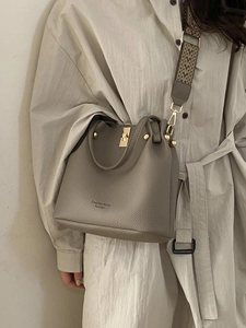 Chic winter bucket bag in taupe pebble leather with wide geometric jacquard strap