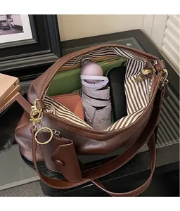 Vista interna di una grande borsa tote in pelle marrone con fodera a righe e ampio spazio
