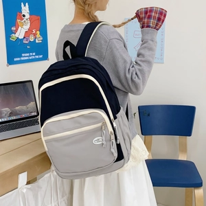 Detail of navy and grey patchwork canvas backpack with large capacity and side pockets