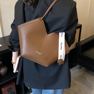 Detailed shot of brown woven tote bag with V-shaped opening and white canvas strap