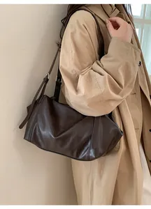 Detail of a deep brown leather tote bag worn with a beige trench coat for a commute style
