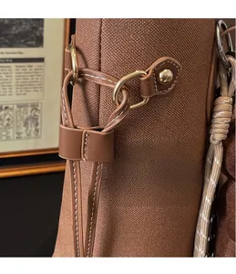 Close-up of golden hardware buckle and white stitching on brown textured tote bag