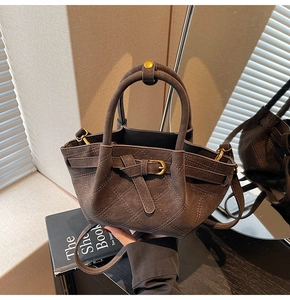 Detail der dunkelbraunen Eimertasche mit gestepptem Wildleder und Metallschnalle
