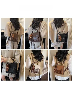 Vista trasera de modelo con mochila vintage de cuero y colgante de osito en varios colores