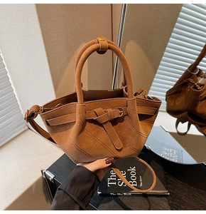 Detail einer Vintage-Eimertasche in Karamellbraun mit Rautensteppung und Metallschnalle