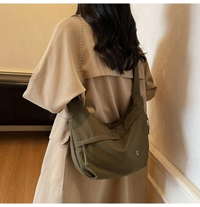 Vue détaillée du sac croissant en nylon vert olive sur modèle avec grande capacité