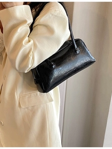 Classic black Boston bag in vintage oil wax leather shown on a model's shoulder