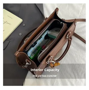 Detail view of large capacity brown leather handbag interior with multi-layer compartments