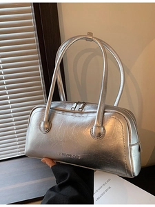 Metallic silver Boston bag with crinkle texture and sleek top handles in natural light