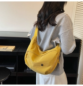 Détail du sac bandoulière croissant en nylon jaune avec sangle réglable et poche zippée