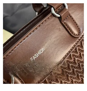Detail of brown quilted leather bag with silver ring hardware and fashion bags logo