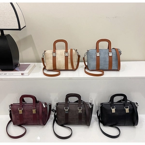 Five premium textured Boston bags in assorted colors displayed on a white tiered shelf
