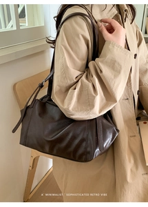 Detail of minimalist dark brown leather shoulder bag with adjustable thin straps and retro vibe