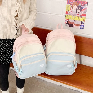 Detail of macaron canvas backpack with dual front zipper pockets and color-block design